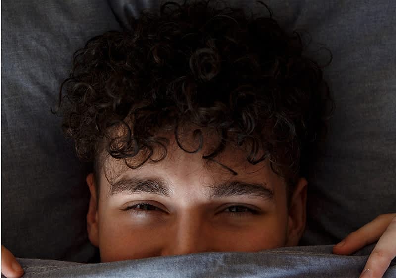 Mann mit Dauerwelle unter Decke