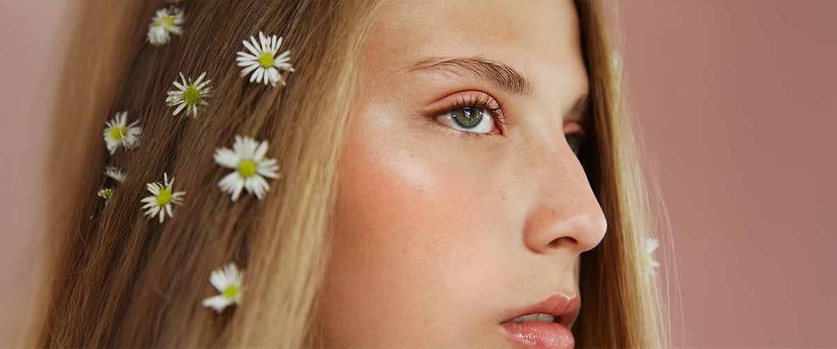 Blumen im Haar mit braunen und blonden Strähnen