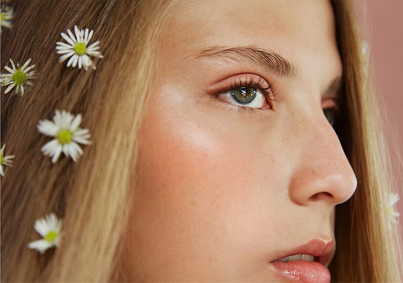 Blumen im Haar mit braunen und blonden Strähnen