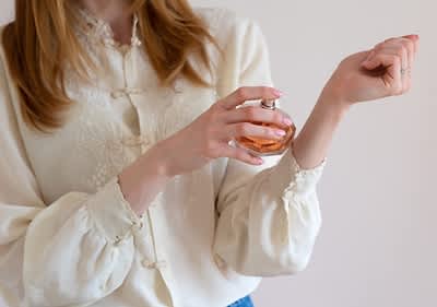Frau die Parfum aufsprüht