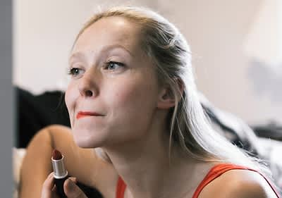 Frau trägt Lippenstift auf.