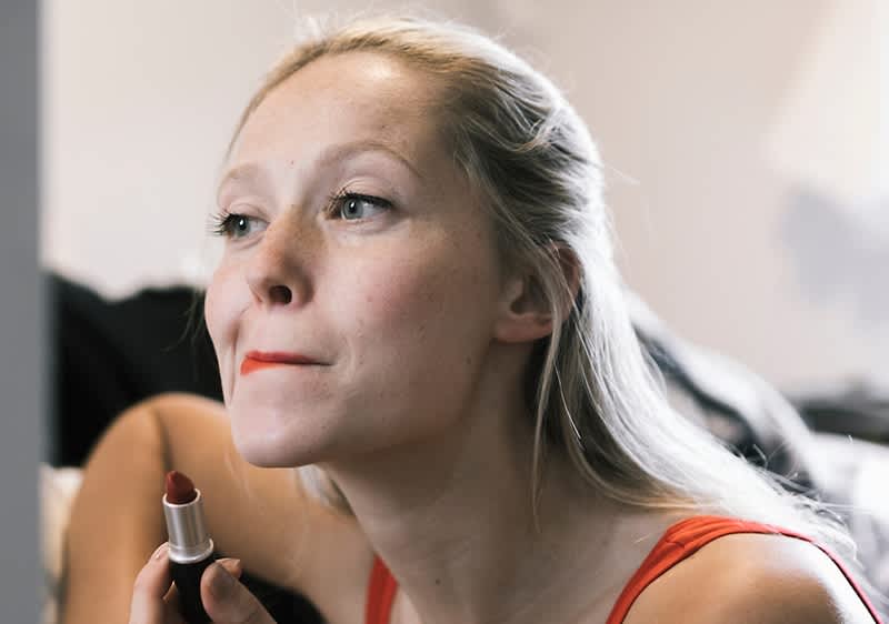 Frau trägt Lippenstift auf.