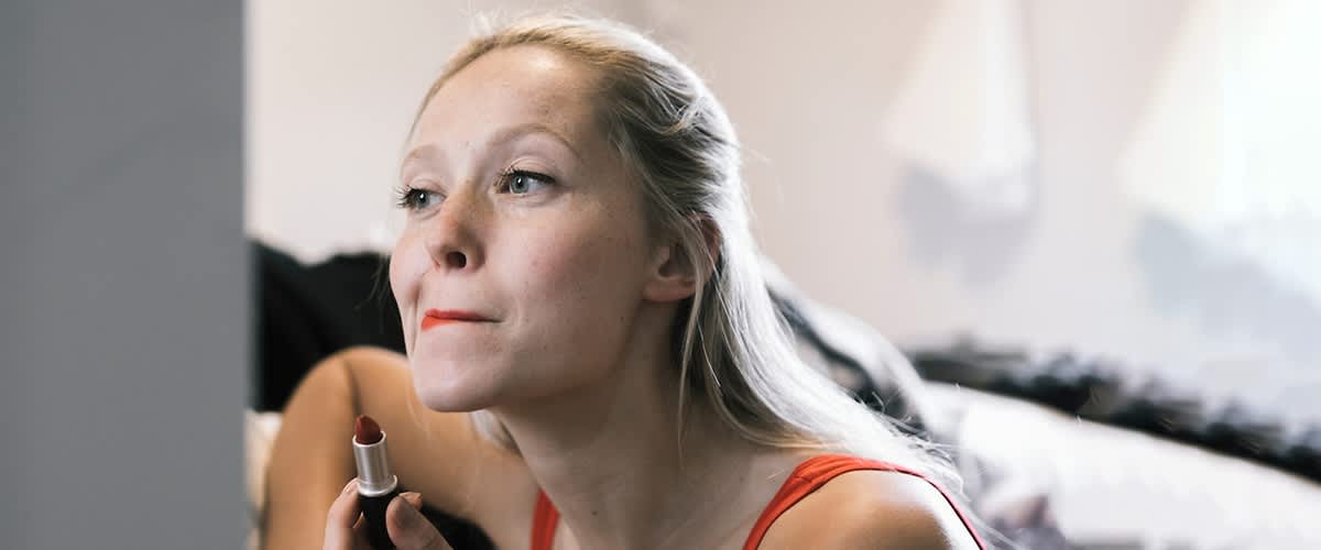 Frau trägt Lippenstift auf.