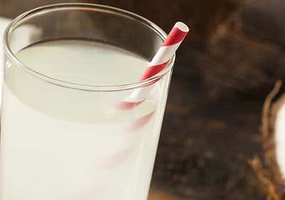 Glas mit Kokoswasser und rot-weißem Strohhalm