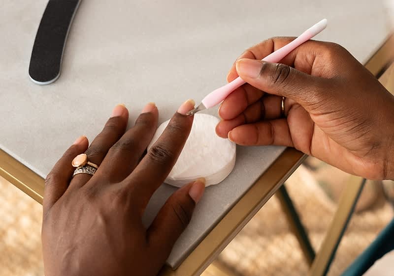 Frau entfernt sich die Nagelhaut