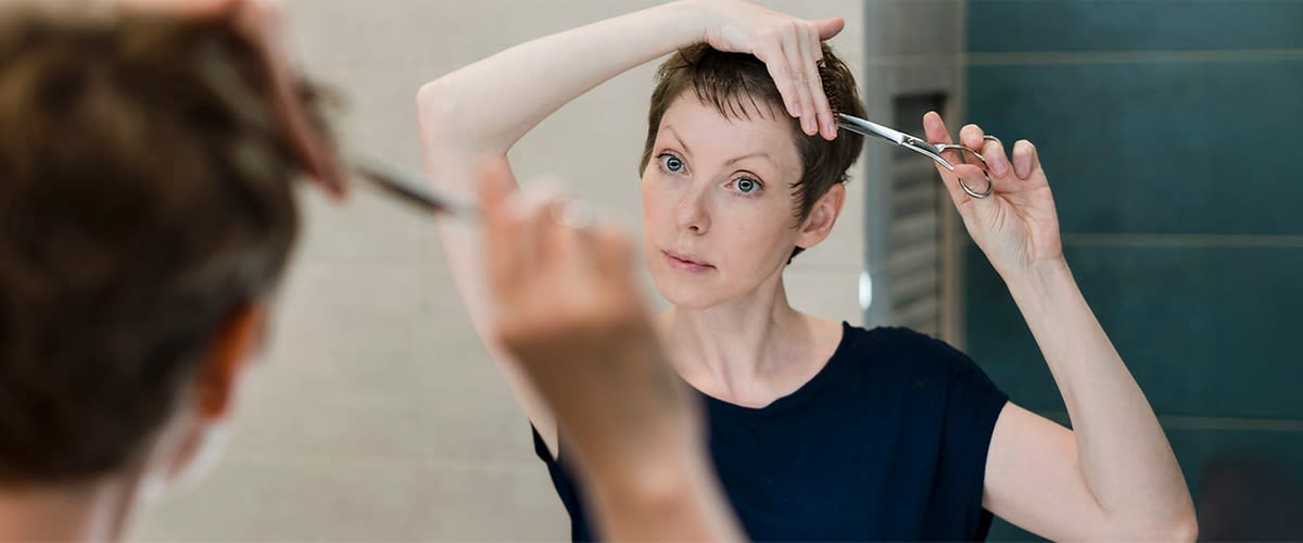 Haarschnitt mit Schere vor Spiegel