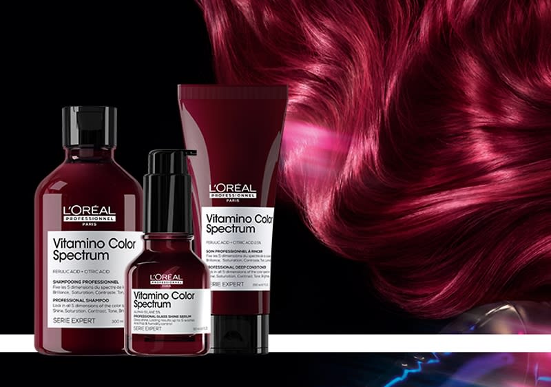 Haarpflegeprodukte von L'Oréal vor rotem Haarhintergrund