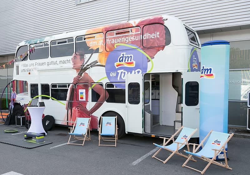 Doppeldeckerbus mit dm-Logo und Liegestühlen für Frauengesundheitstour