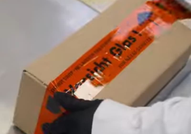 Paket mit rotem Klebeband und schwarzer Schrift