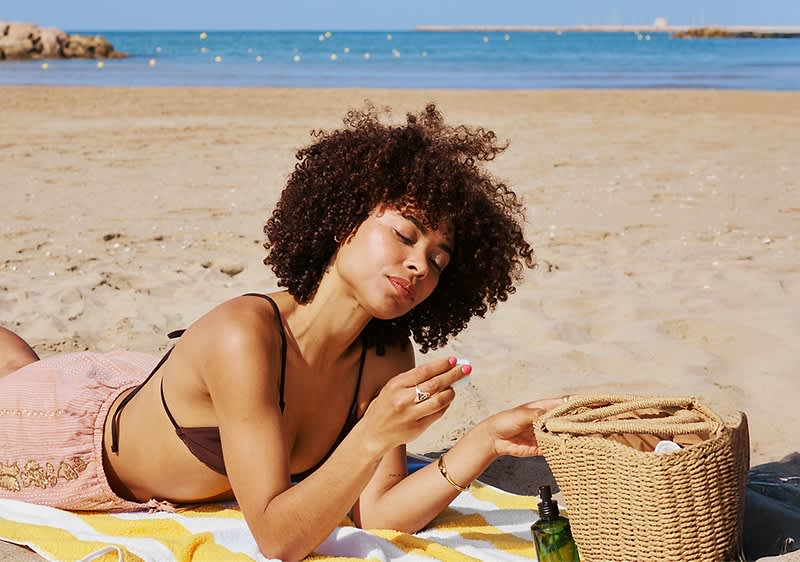 Frau am Strand mit Korb und Meer im Hintergrund