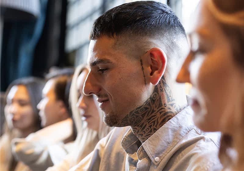 Tätowierter Mann mit Hemd in einem Café