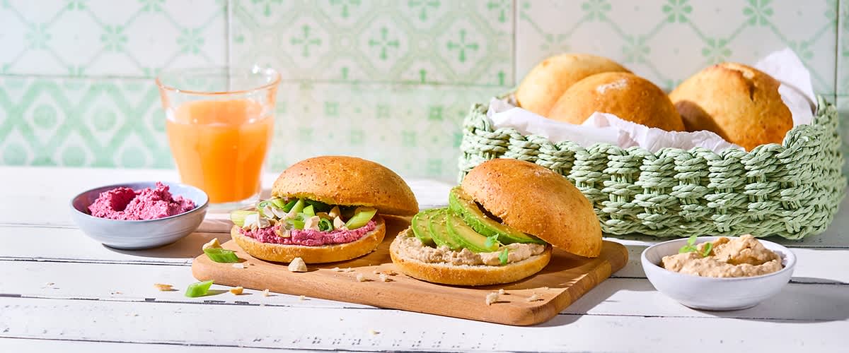 Glutenfreie Brötchen mit Avocado und Aufstrich auf Holzbrett
