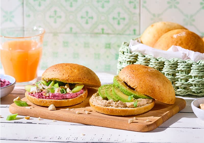 Glutenfreie Brötchen mit Avocado und Aufstrich auf Holzbrett