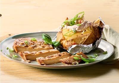 Gebackene Kartoffel mit Kräuterquark und gegrilltem Seitansteak auf Teller