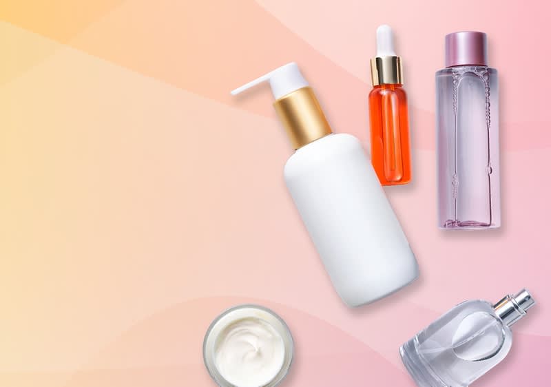 Eine transparente Parfümflasche mit rosa Verschluss auf einem rosa Hintergrund