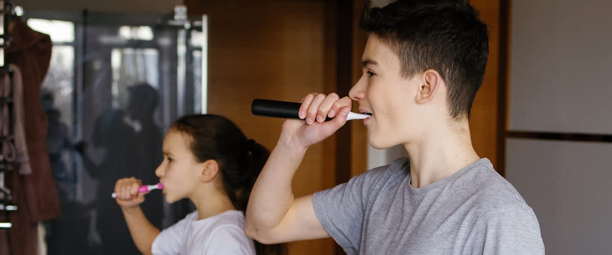 Zwei Kinder beim Zaehneputzen im Badezimmer