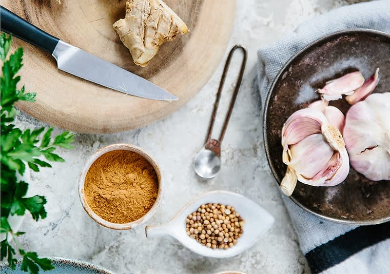 Küchenzutaten mit Ingwer Knoblauch und Gewürzen auf einem Tisch