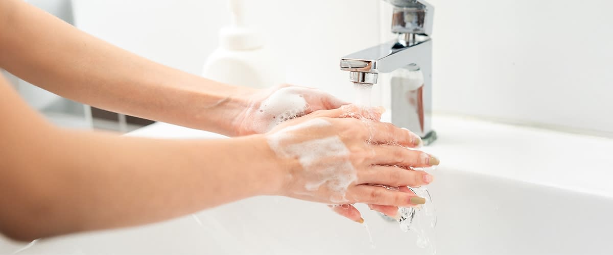 Händewaschen unter fließendem Wasser mit Seifenschaum