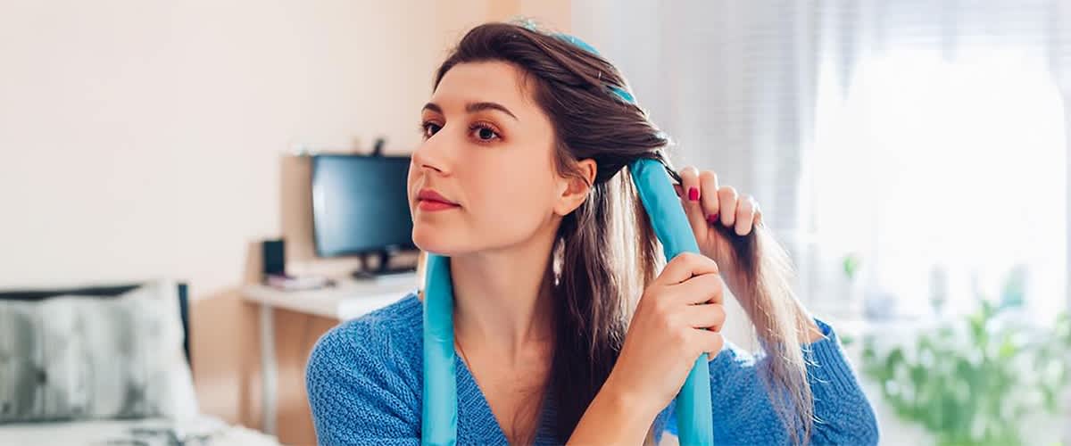 Frau mit Lockenwickler im Haar in einem Zimmer