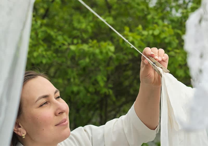 Wäsche aufhängen im Freien mit grünen Bäumen im Hintergrund