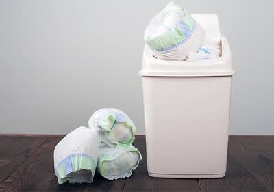 Windeleimer mit Windeln auf Holzboden