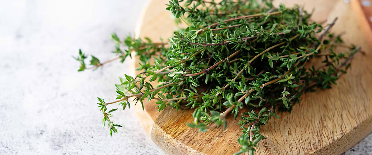 Thymianzweige auf einem Holzbrett