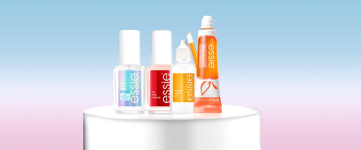 Nagelpflegeprodukte von Essie auf Podest vor blauem Hintergrund