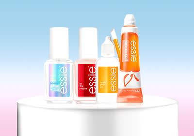 Nagelpflegeprodukte von Essie auf Podest vor blauem Hintergrund