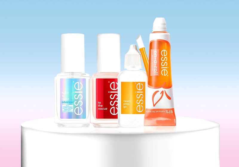 Nagelpflegeprodukte von Essie auf Podest vor blauem Hintergrund