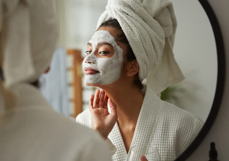 Frau mit Handtuch-Turban beim eincremen
