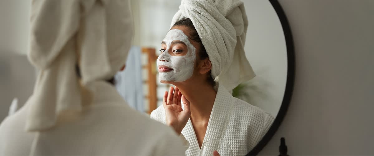 Frau mit Handtuch-Turban beim eincremen