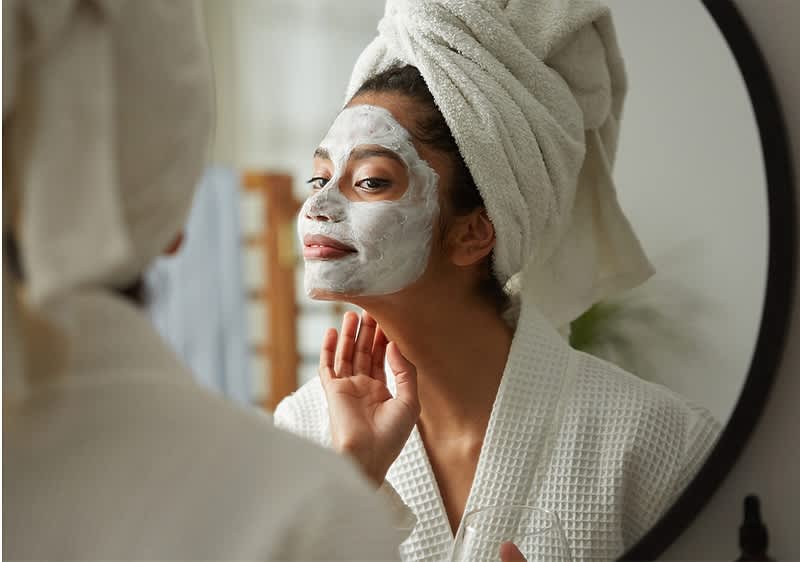 Frau mit Handtuch-Turban beim eincremen