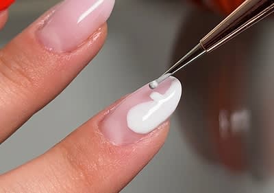 Nageldesign mit weißem Gel auf einem Fingernagel