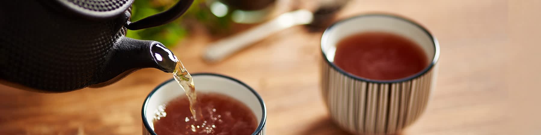 Tee wird in eine Tasse gegossen