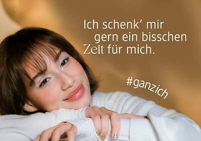 Frau in weißem Pullover mit Schriftzug Ich schenk' mir gern ein bisschen Zeit für mich und Hashtag #ganzich