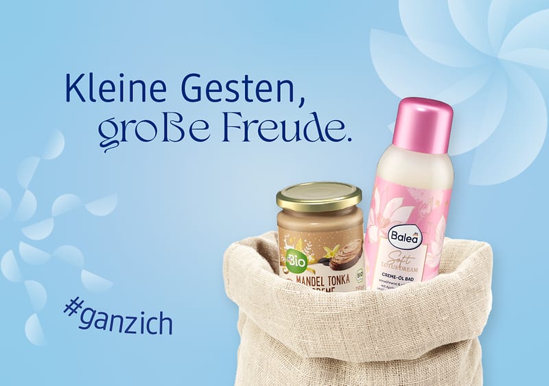 Ein beiger Nikolaussack enthält ein Glas Bio-Mandel-Tonka-Creme und eine Balea Creme-Öl-Dusche mit rosa Deckel, daneben der Text „Kleine Gesten, große Freude“ und der Hashtag „#ganzich“ auf blauem Hintergrund