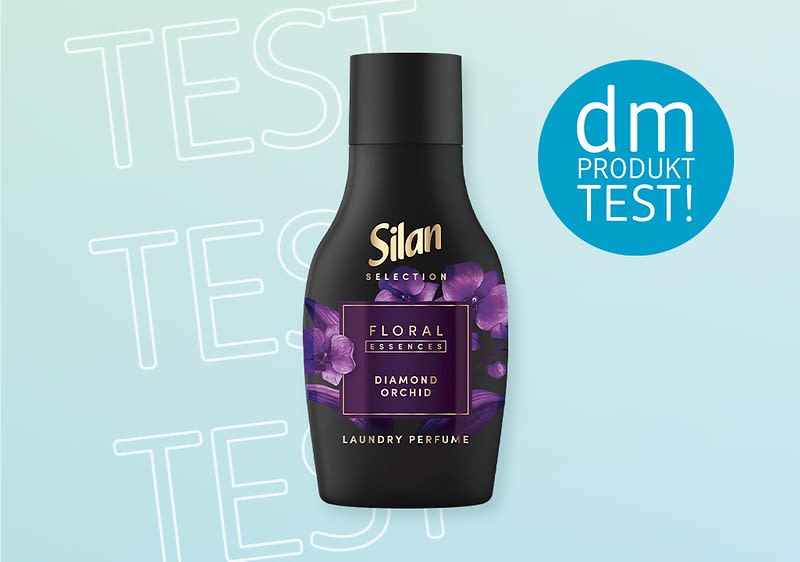Eine schwarze Silan-Flasche mit lila Blumen und der Aufschrift „Floral Diamond Orchid“ auf hellblauem Hintergrund mit „dm Produkttest“ in einem Kreis