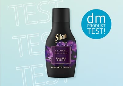 Eine schwarze Silan-Flasche mit violetten Blumen und der Aufschrift „Floral Diamond Orchid“ auf hellblauem Hintergrund mit „dm Produkttest“ in einem Kreis