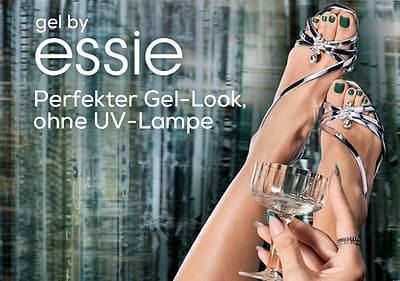 Zwei Füße in silbernen Sandalen mit grünen Zehennägeln, eine Hand hält ein Glas, Text: „gel by essie Perfekter Gel-Look, ohne UV-Lampe“