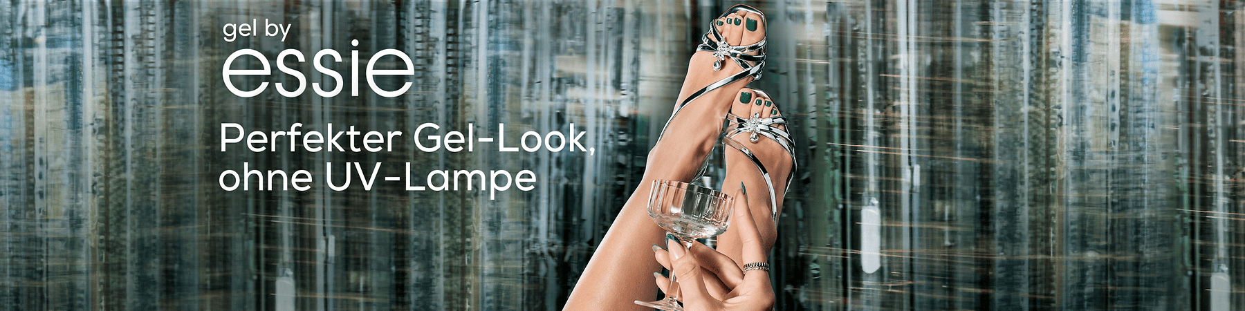 Zwei Füße in silbernen Sandalen mit grünen Zehennägeln, eine Hand hält ein Glas, Text: „gel by essie Perfekter Gel-Look, ohne UV-Lampe“