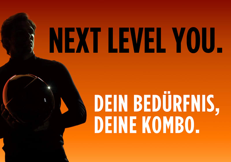 Ein Mann hält einen Helm, daneben der Text „NEXT LEVEL YOU. DEIN BEDÜRFNIS, DEINE KOMBO.“ auf orangefarbenem Hintergrund