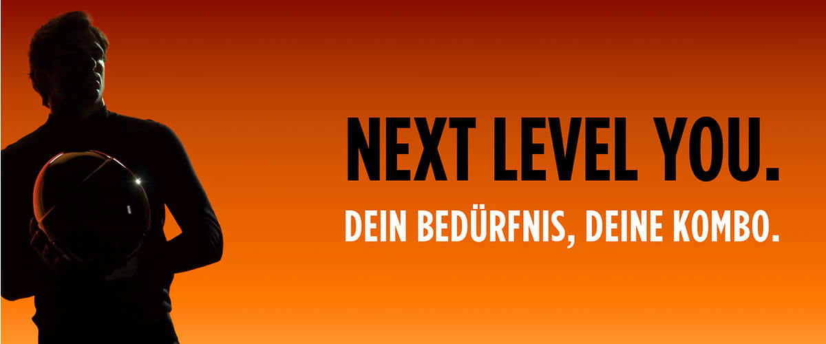 Ein Mann hält einen Helm, daneben der Text „NEXT LEVEL YOU. DEIN BEDÜRFNIS, DEINE KOMBO.“ auf orangefarbenem Hintergrund