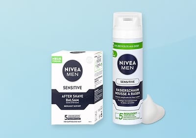 Eine Nivea Men Verpackung für After Shave Balsam und eine Rasiercreme-Flasche mit der Aufschrift „Sensitive“ auf blauem Hintergrund