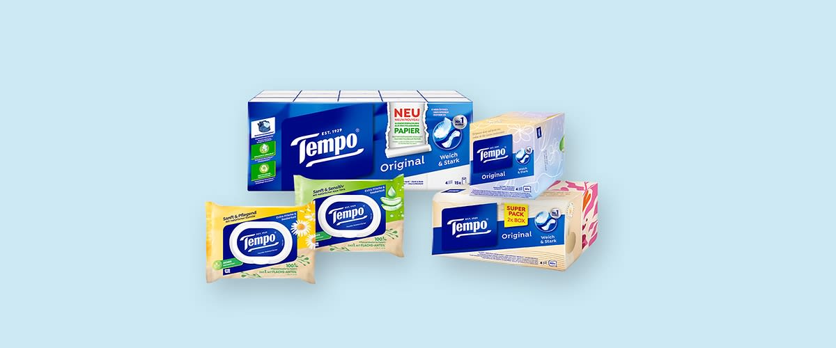 Mehrere Tempo Taschentuchpackungen in verschiedenen Größen und Designs, darunter Original und Super Pack, auf hellblauem Hintergrund