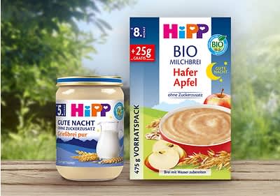 Eine Packung Hipp Bio Milchbrei Hafer Apfel mit 475g, daneben ein Glas Hipp Gute Nacht Grießbrei pur mit 190g