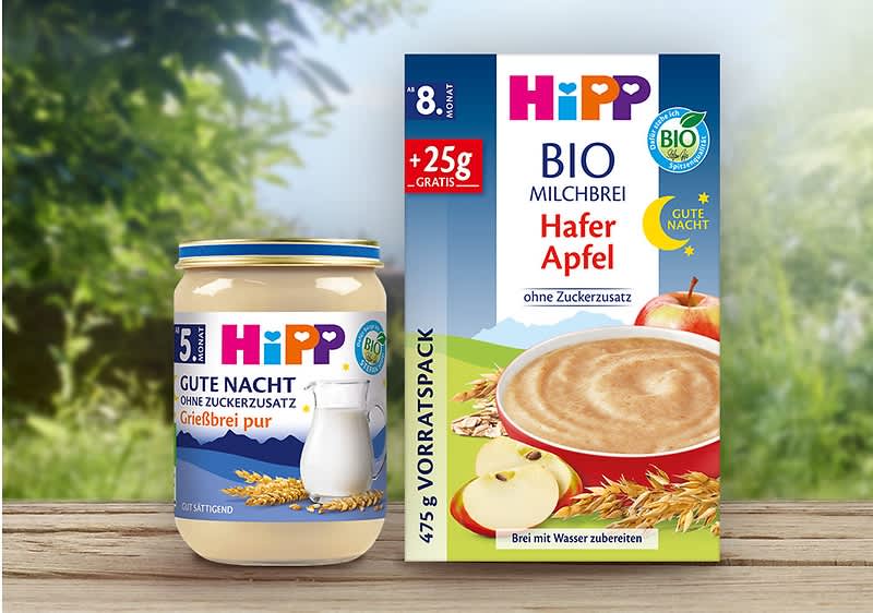 Eine Packung Hipp Bio Milchbrei Hafer Apfel mit 475g, daneben ein Glas Hipp Gute Nacht Grießbrei pur mit 190g