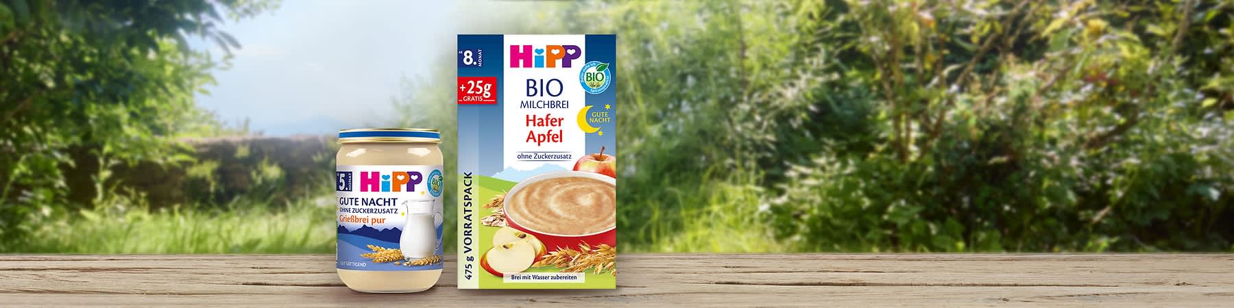 Eine Packung Hipp Bio Milchbrei Hafer Apfel mit 475g, daneben ein Glas Hipp Gute Nacht Grießbrei pur mit 190g