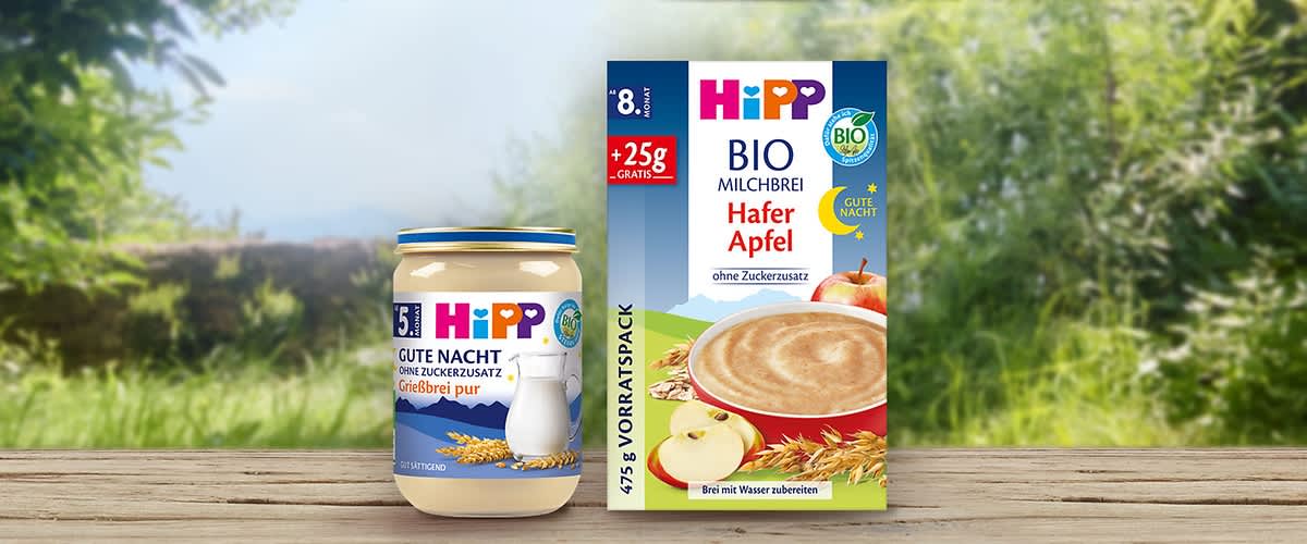 Eine Packung Hipp Bio Milchbrei Hafer Apfel mit 475g, daneben ein Glas Hipp Gute Nacht Grießbrei pur mit 190g