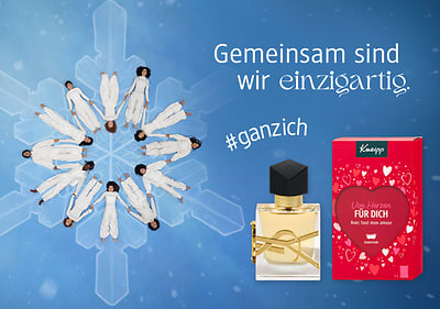 Eine Schneeflocken-Formation aus tanzenden Personen, daneben ein Parfümflakon und eine rote Verpackung mit der Aufschrift „Von Herzen FÜR DICH“ sowie „#ganzich“ und „Gemeinsam sind wir einzigartig“