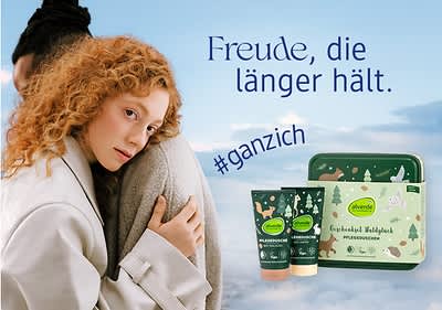 Eine Frau mit lockigem Haar umarmt eine Person, daneben Alverde-Pflegeprodukte und der Text „Freude, die länger hält. #ganzich“
